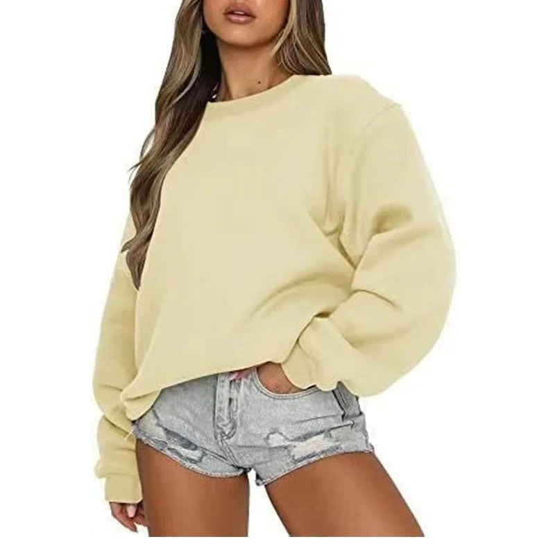 Pale yellow oversized sweatshirt styled with light denim shorts, highlighting its roomy fit and clean crew neckline.