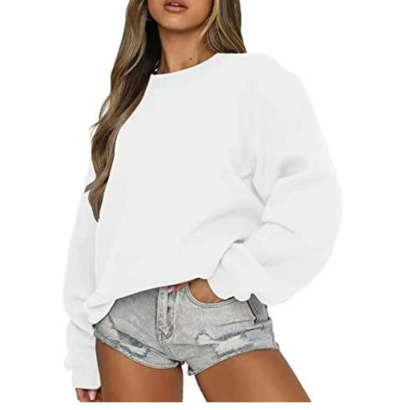 White oversized crew neck sweatshirt on a model, with long sleeves extending to ribbed cuffs and a relaxed hem.