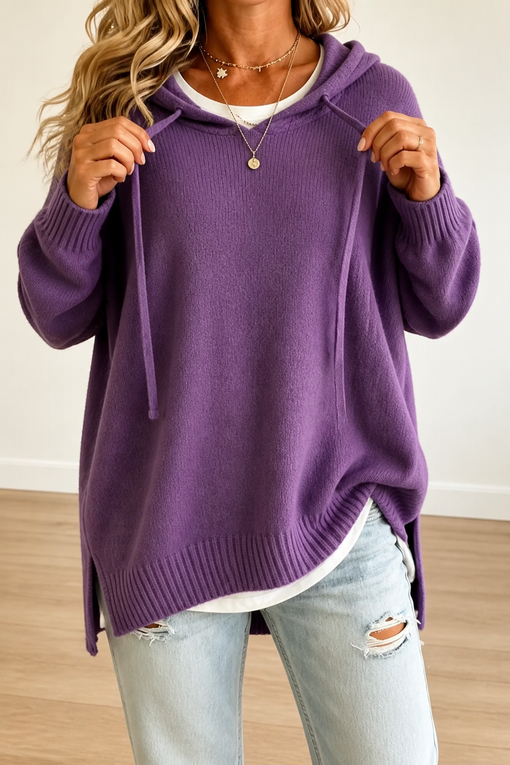 Front view of the oversized hooded sweater in purple, showing the roomy silhouette and ribbed cuffs.