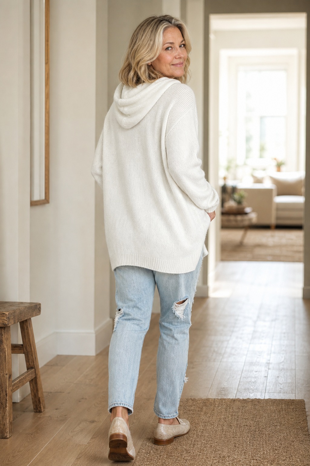 Back and side view of the ivory oversized sweater, showing the hood, dropped shoulders, and longer rounded hem.