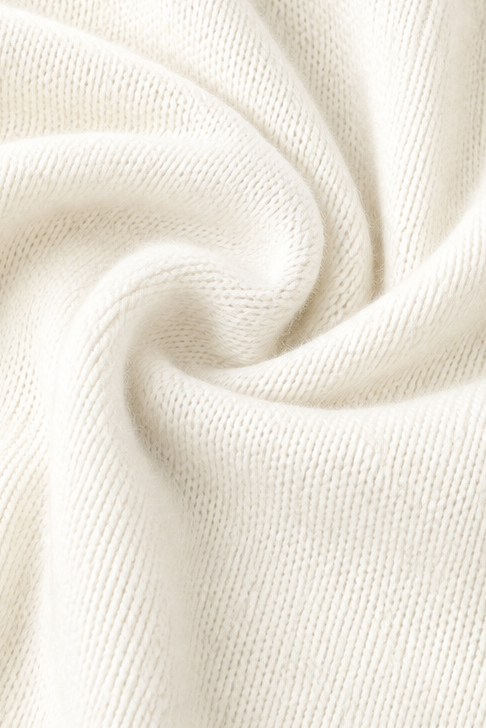 Detailed close-up showing the sweater’s fine textured knit surface in ivory.