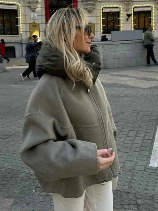 Front three-quarter view of Clare's oversized jacket with a raised quilted hooded collar, front zip, and wide sleeves.