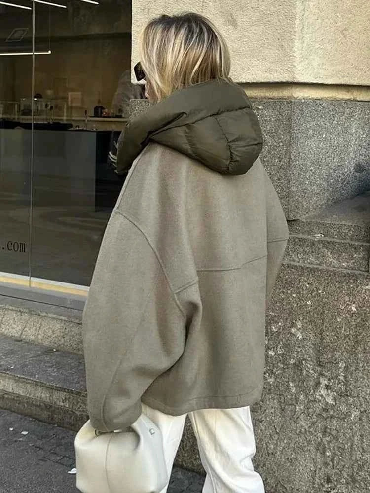 Rear three-quarter view of the jacket displaying its relaxed back, oversized hood, and broad sleeve shape.