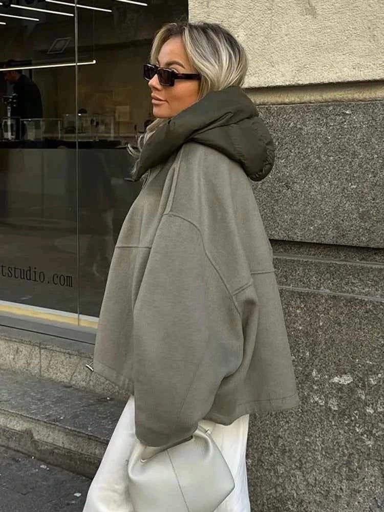 Side profile of the oversized jacket with its raised collar, draped wide sleeve, and relaxed hem.