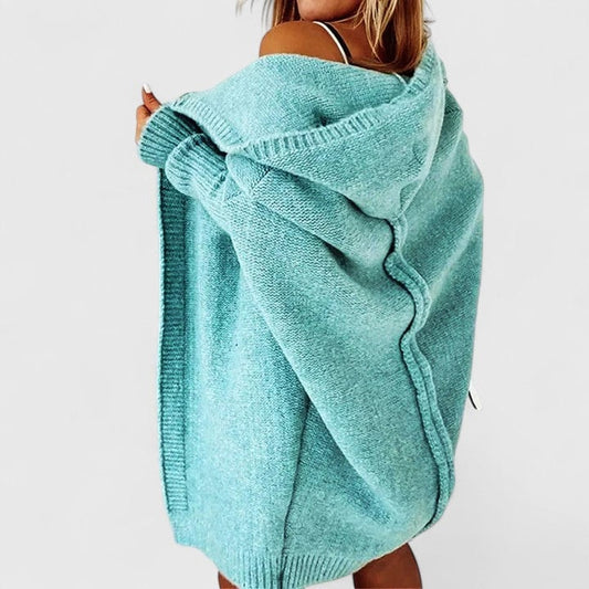 Turquoise oversized hooded cardigan shown from the back with its open front wrapped loosely around the body and ribbed sleeve cuffs visible.