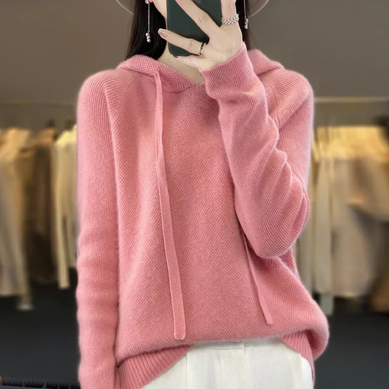 Soft pink oversized knit hoodie with a relaxed silhouette, long drawstrings, and ribbed sleeve cuffs.
