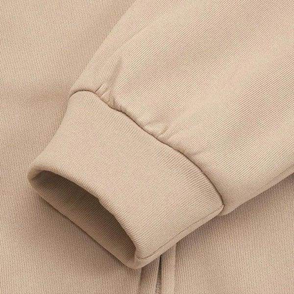 Close-up of the beige hoodie sleeve showing the wide ribbed cuff and gathered sleeve construction.