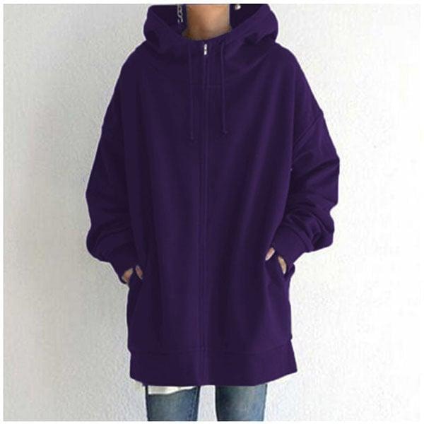 Front view of the oversized longline zip-up hoodie in deep purple with hands placed in the side pockets.