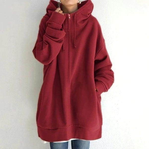 Front view of the longline zip-up hoodie in brick red, showing the raised hood, front zip, and relaxed fit.