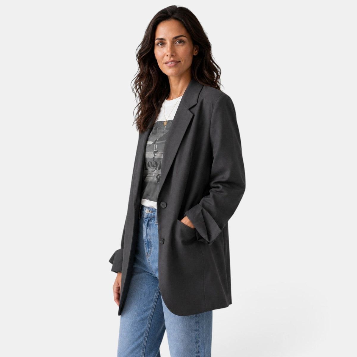 Angled view of the charcoal oversized blazer showing its relaxed longline shape, notched lapel, button closure, and pocket flap.
