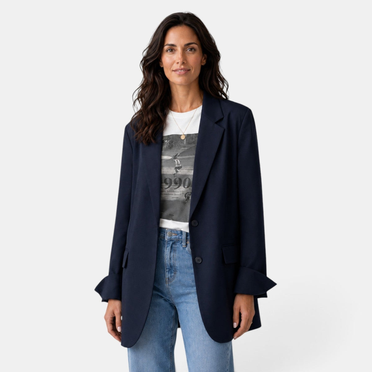 Front view of a navy oversized two-button blazer worn open over a graphic T-shirt and jeans, featuring notched lapels and flap pockets.