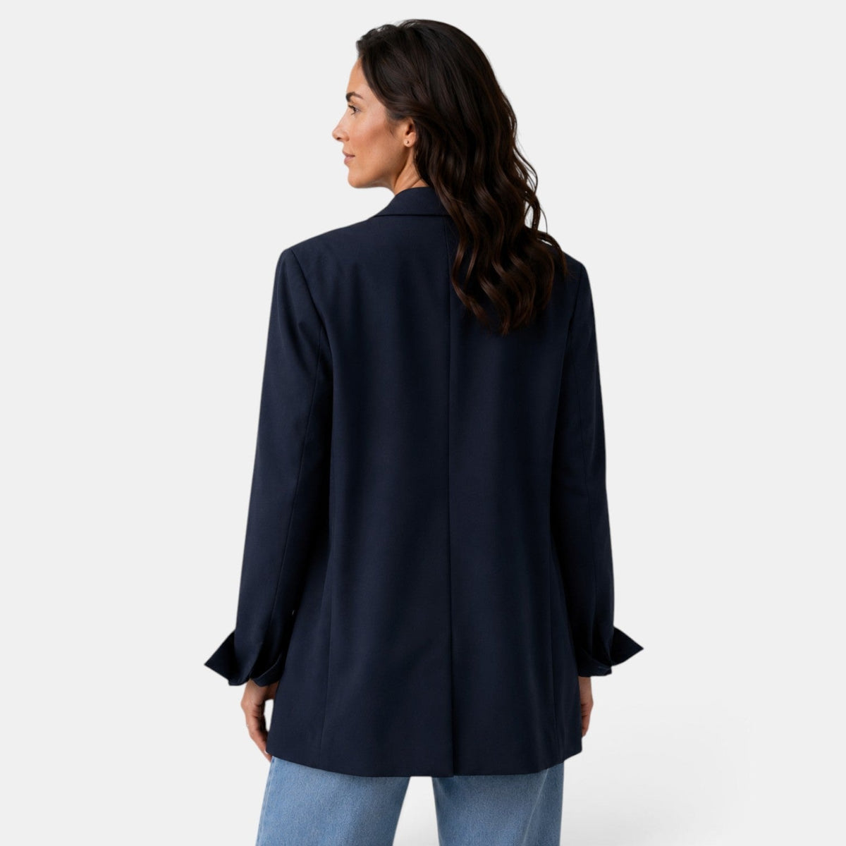 Back view of the navy oversized blazer showing the smooth relaxed shape, center back seam, and distinctive split cuffs.