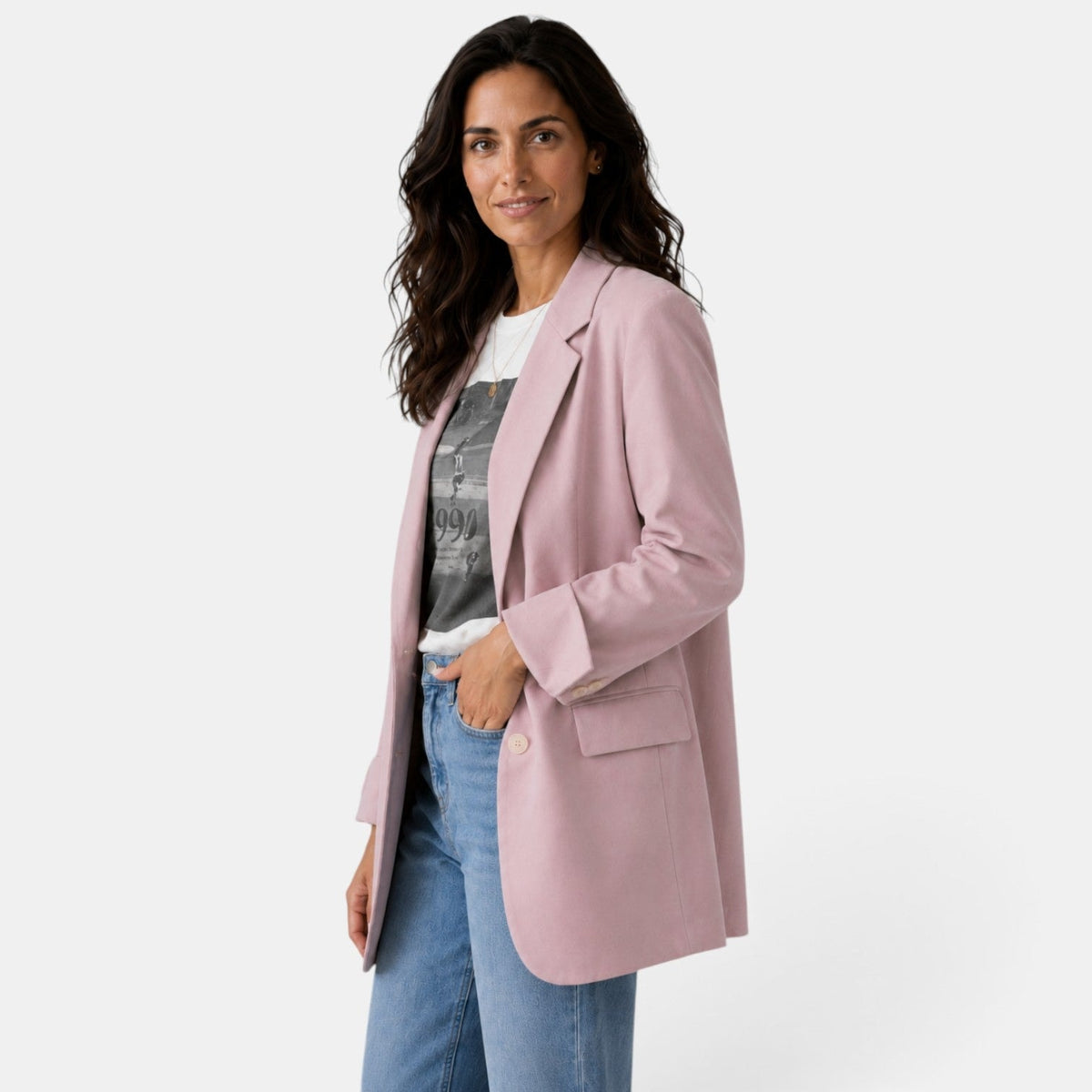Angled view of the blush pink blazer showing the relaxed fit, button closure, long sleeve, notched lapel, and side flap pocket.