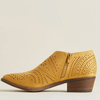 Side profile of a mustard-yellow perforated ankle boot showing its side zipper, rounded toe, and low stacked block heel.