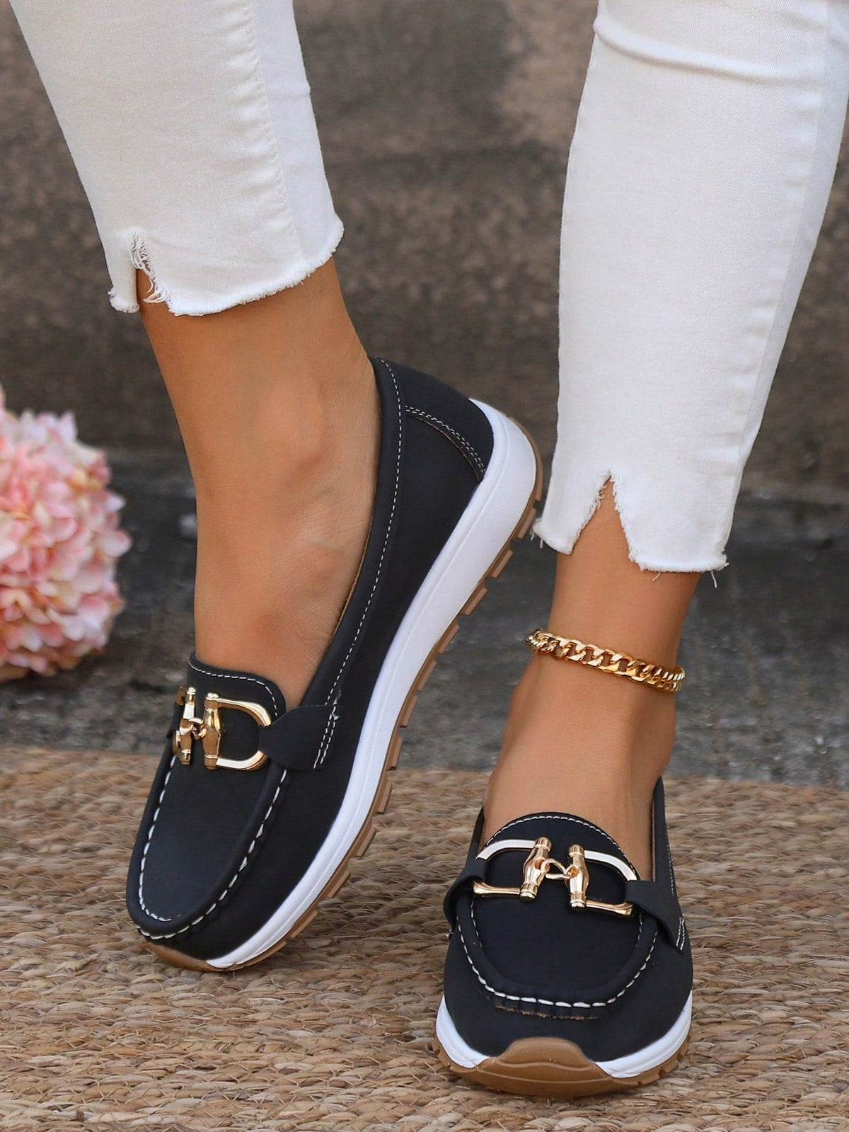 Black platform loafers with contrasting white soles, brown textured outsoles, rounded moc-toes, and gold-tone buckle details.