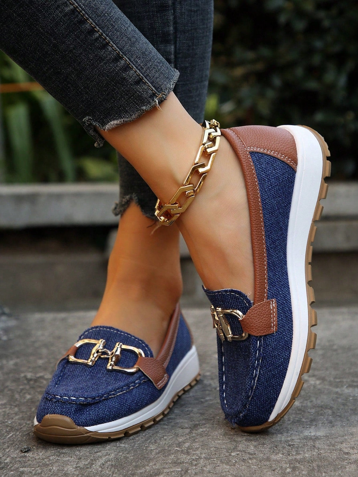 Blue platform loafers with brown contrast panels, white soles, textured outsoles, and gold-tone buckles shown from the side.