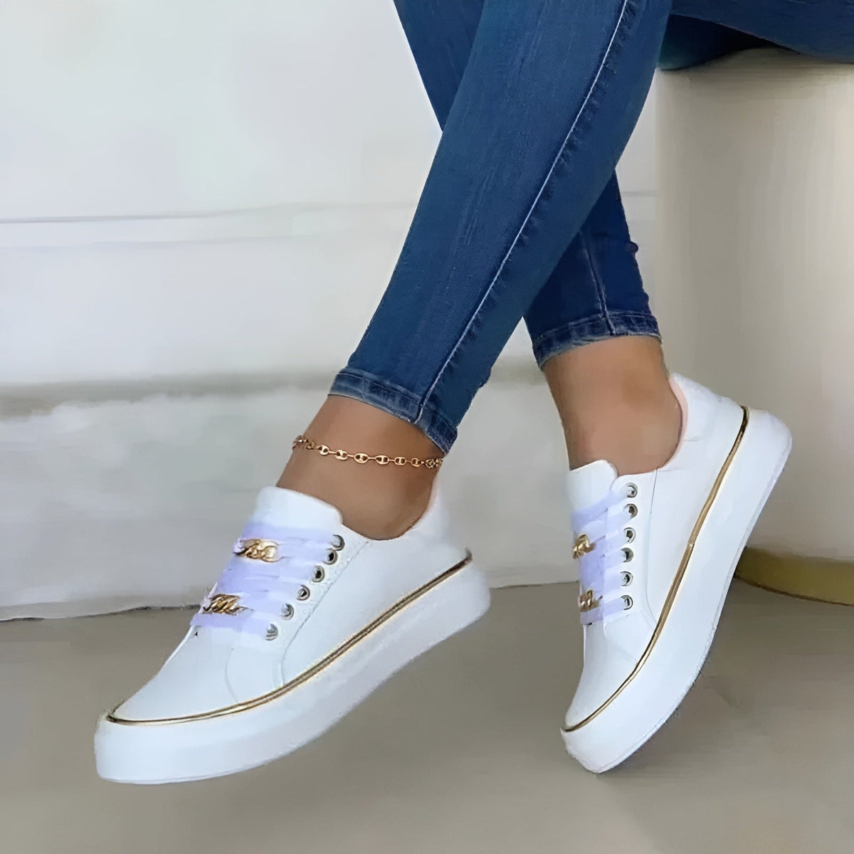 White platform sneakers shown from the side and front, highlighting their raised soles, low-top shape, lace-up closure, and metallic edging.