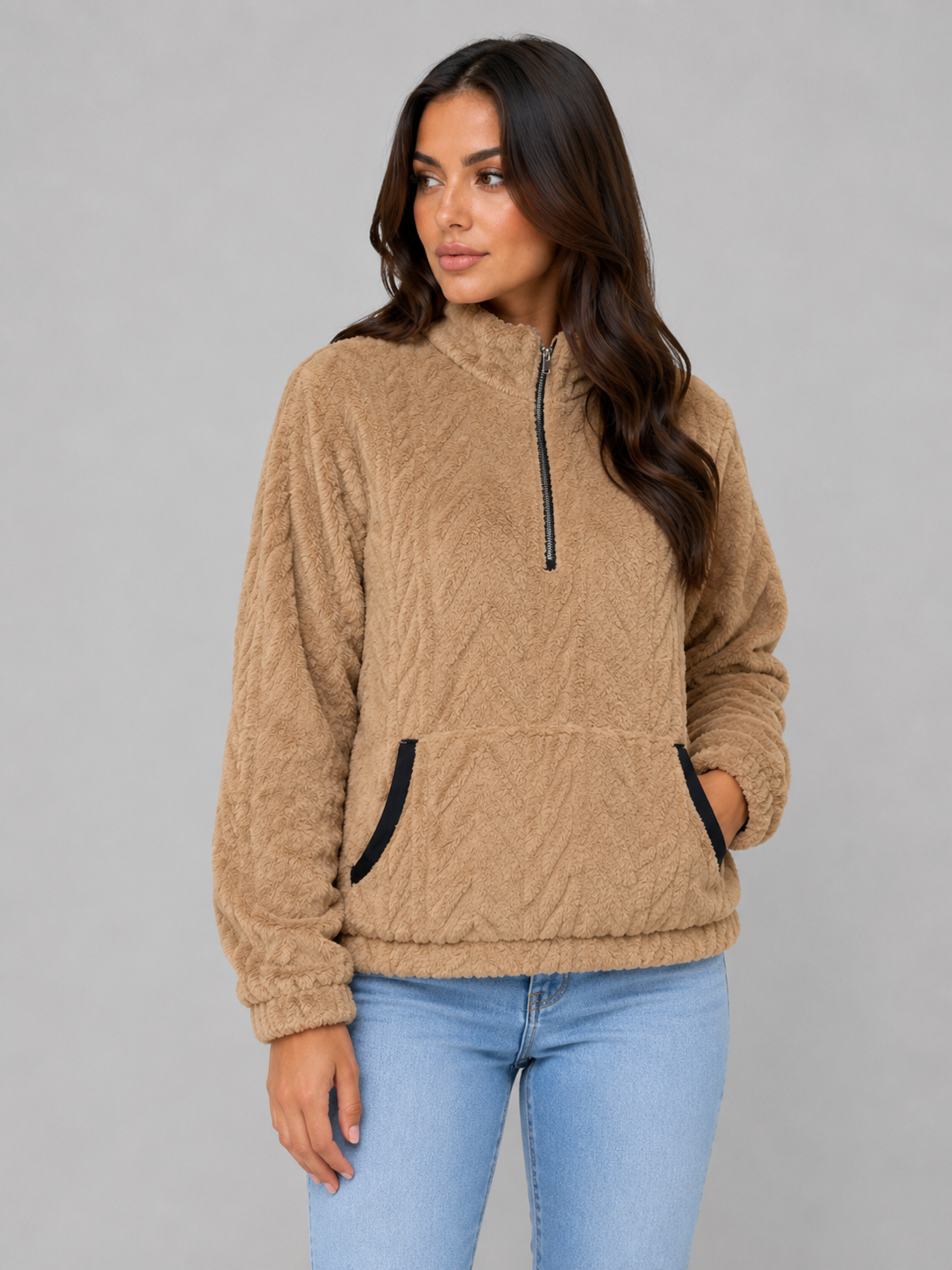 Tan plush half-zip pullover shown at an angle, with black-trimmed pocket openings and elasticated cuffs.