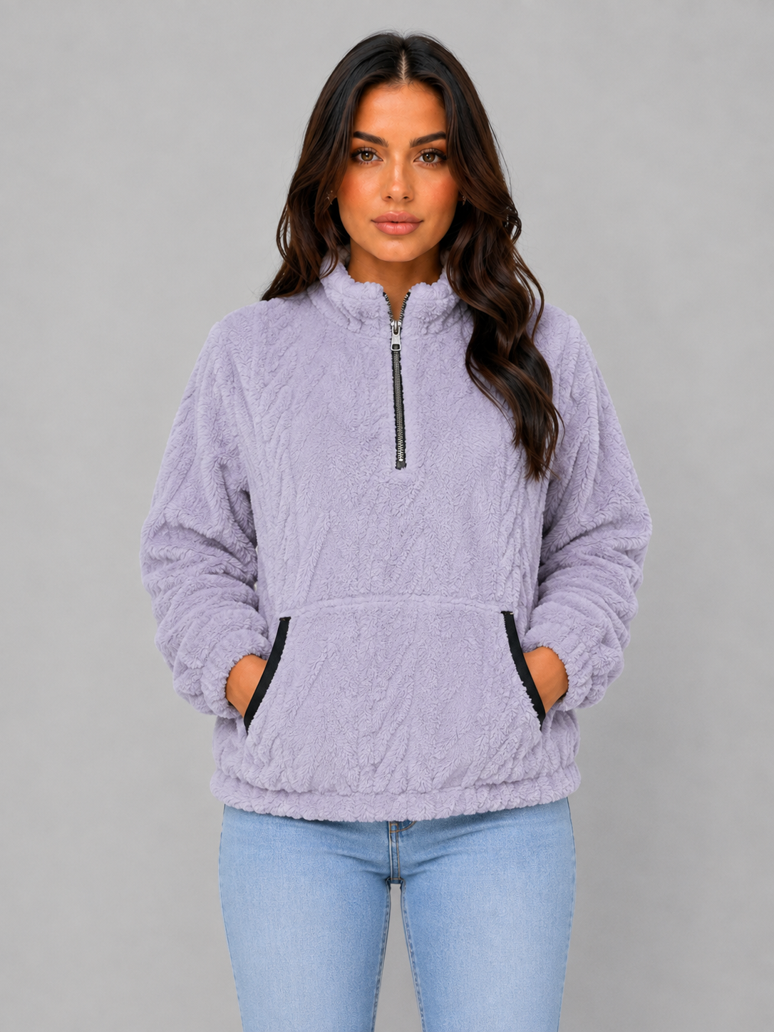 Lavender plush half-zip pullover shown from the front with both hands in the kangaroo pocket.