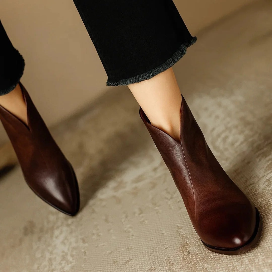 Close view of a brown ankle boot highlighting the pointed toe, diagonal opening, and smooth upper.