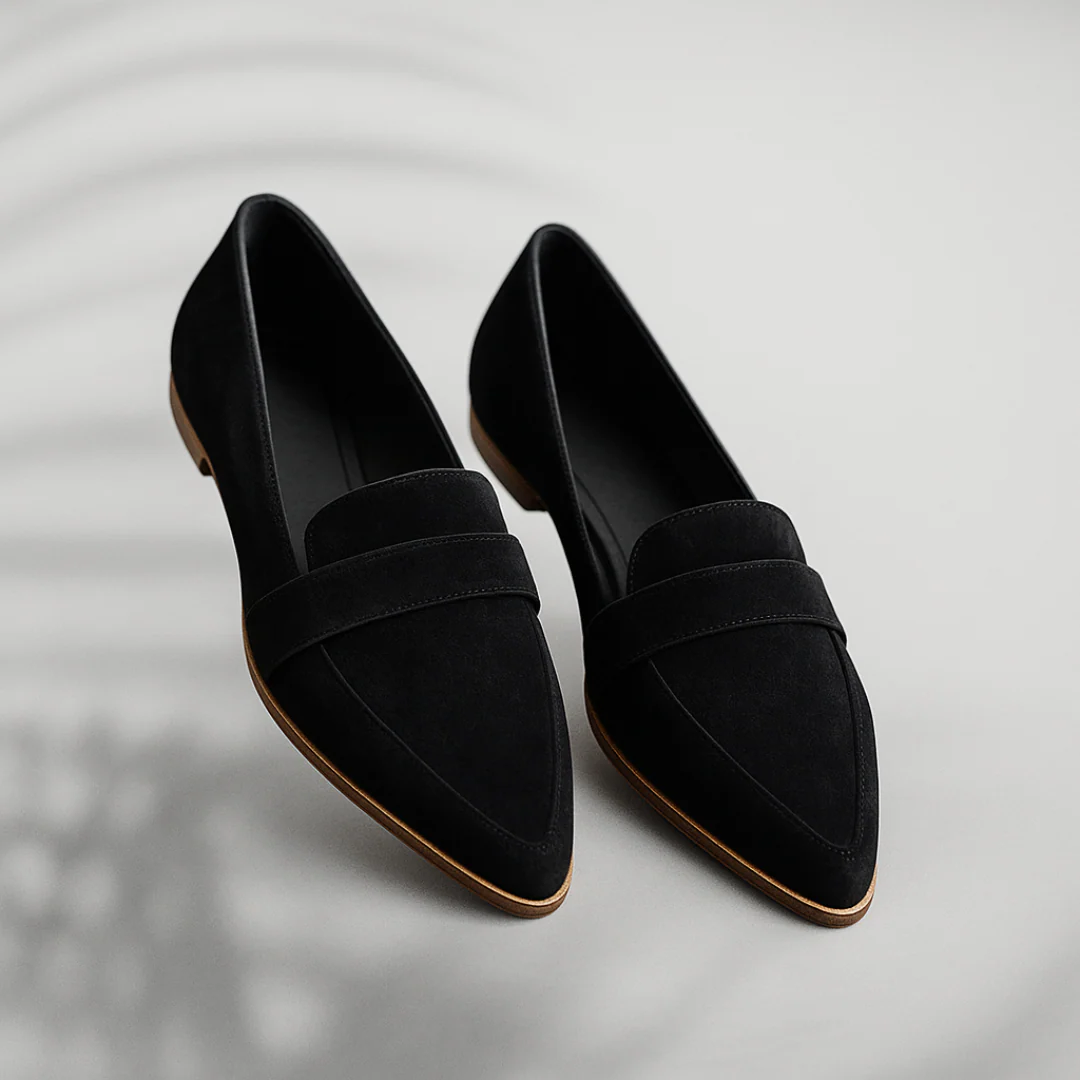 Pair of black pointed toe slip-on loafers displayed separately, showing their sleek low-profile shape and layered upper straps.