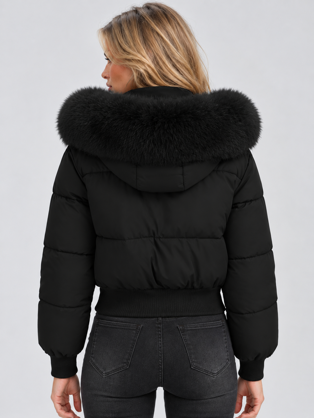 Back view of the black cropped puffer jacket, showing the wide faux fur collar, quilted panels, long sleeves and ribbed hem.