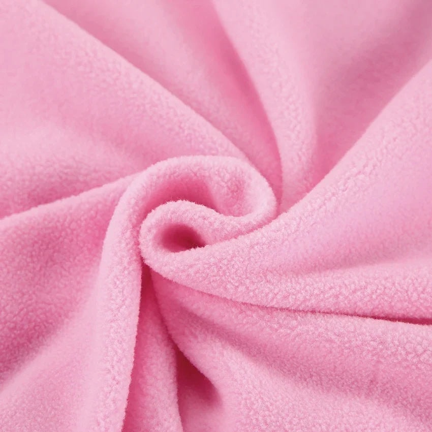 Close-up view of the soft pink brushed surface and folded texture of the sweatshirt.