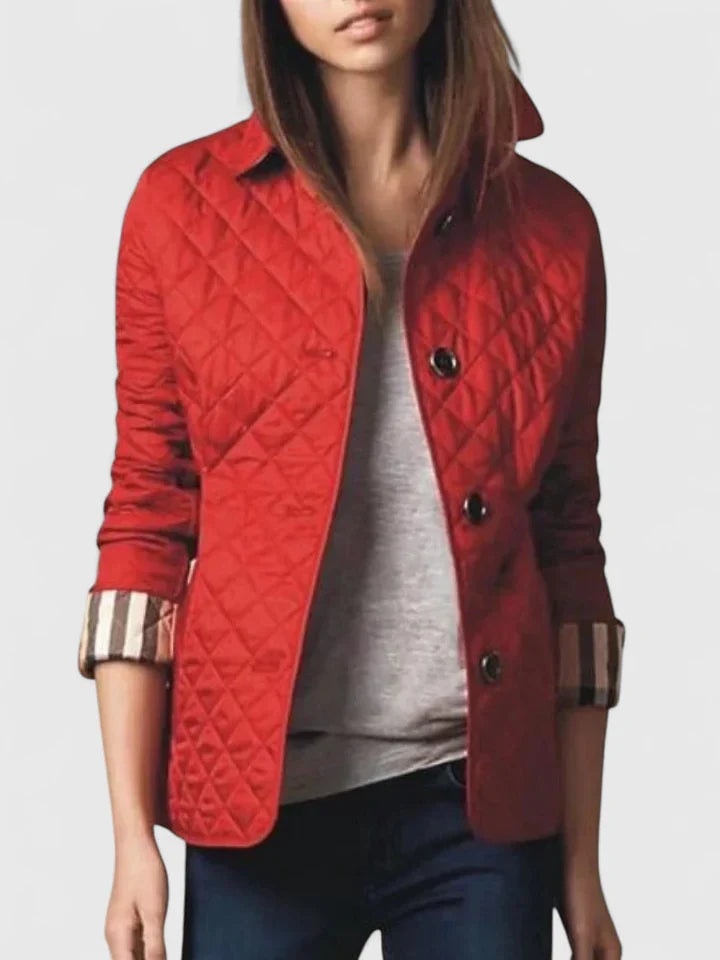 Bright red quilted button-front jacket worn open over a gray top, with rolled sleeves showing checked cuffs.