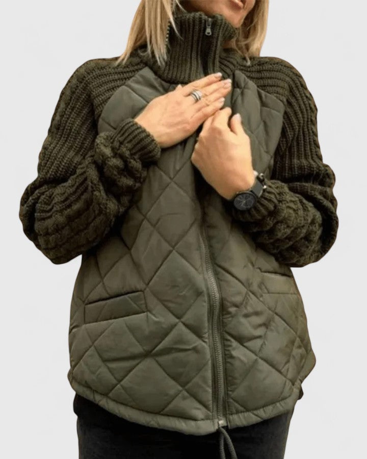 Olive green quilted jacket with textured sleeves shown zipped up as the wearer adjusts the high collar.