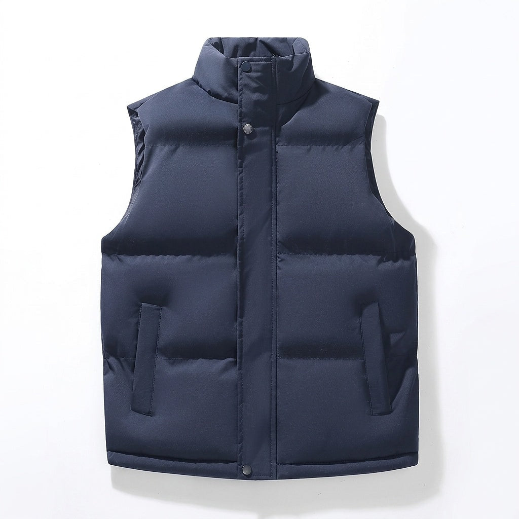 Front view of a navy puffer vest with a stand collar, visible snap closure, horizontal quilted panels, and two side pockets.