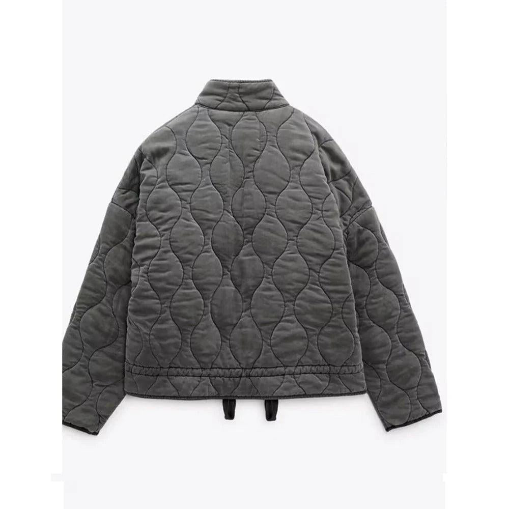 Back view of the dark gray short quilted jacket, showing the continuous wavy quilt pattern, stand collar, long sleeves, and cropped hem.