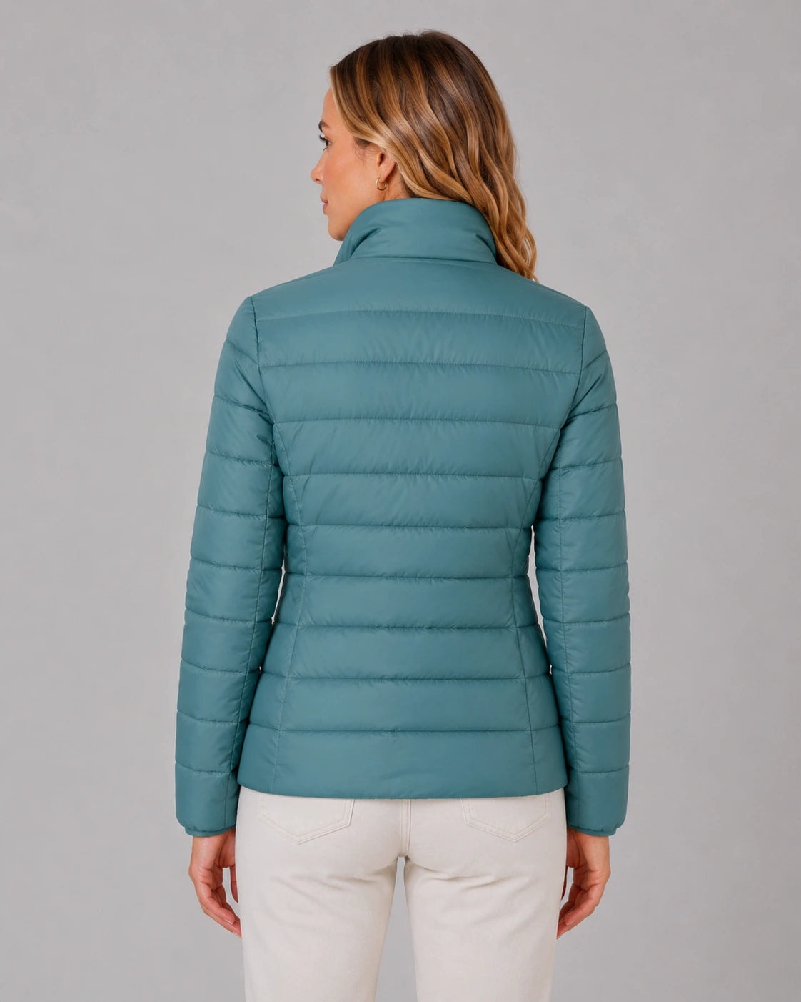 Back view of the teal quilted jacket, showing horizontal stitching, long sleeves, and the stand collar.