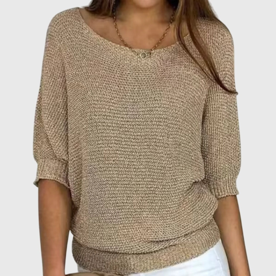 Beige relaxed-fit sweater showing its wide boat neckline and softly textured knit surface.