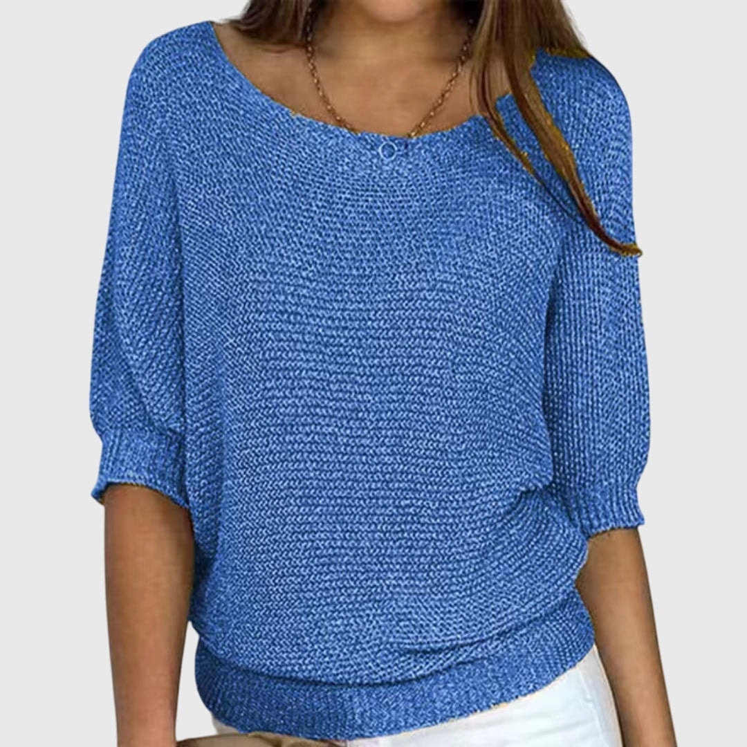 Blue relaxed sweater styled with a wide neckline, textured knit, and defined ribbed hem.