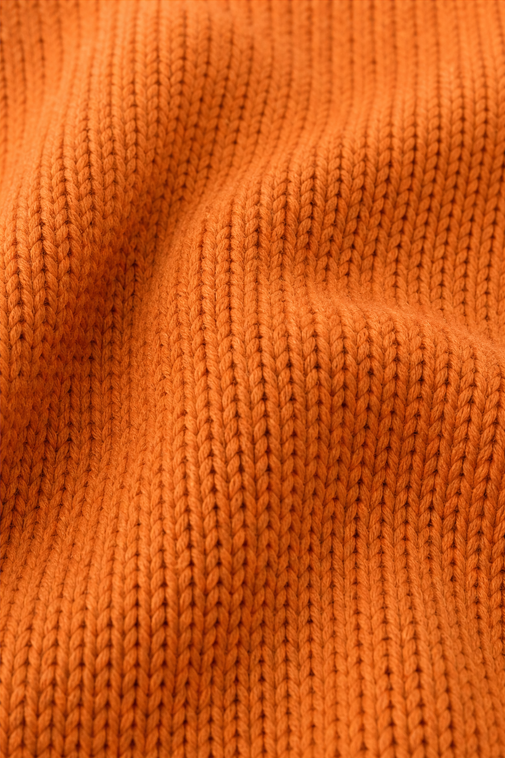 Detailed close-up showing the pullover’s textured ribbed knit surface.