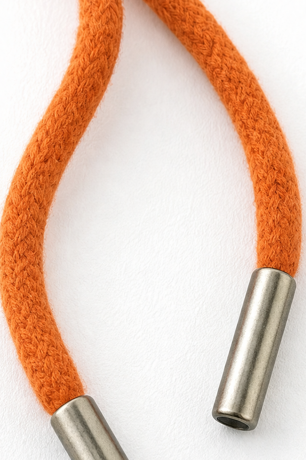 Close-up of an orange hood drawstring with contrasting metal end caps.