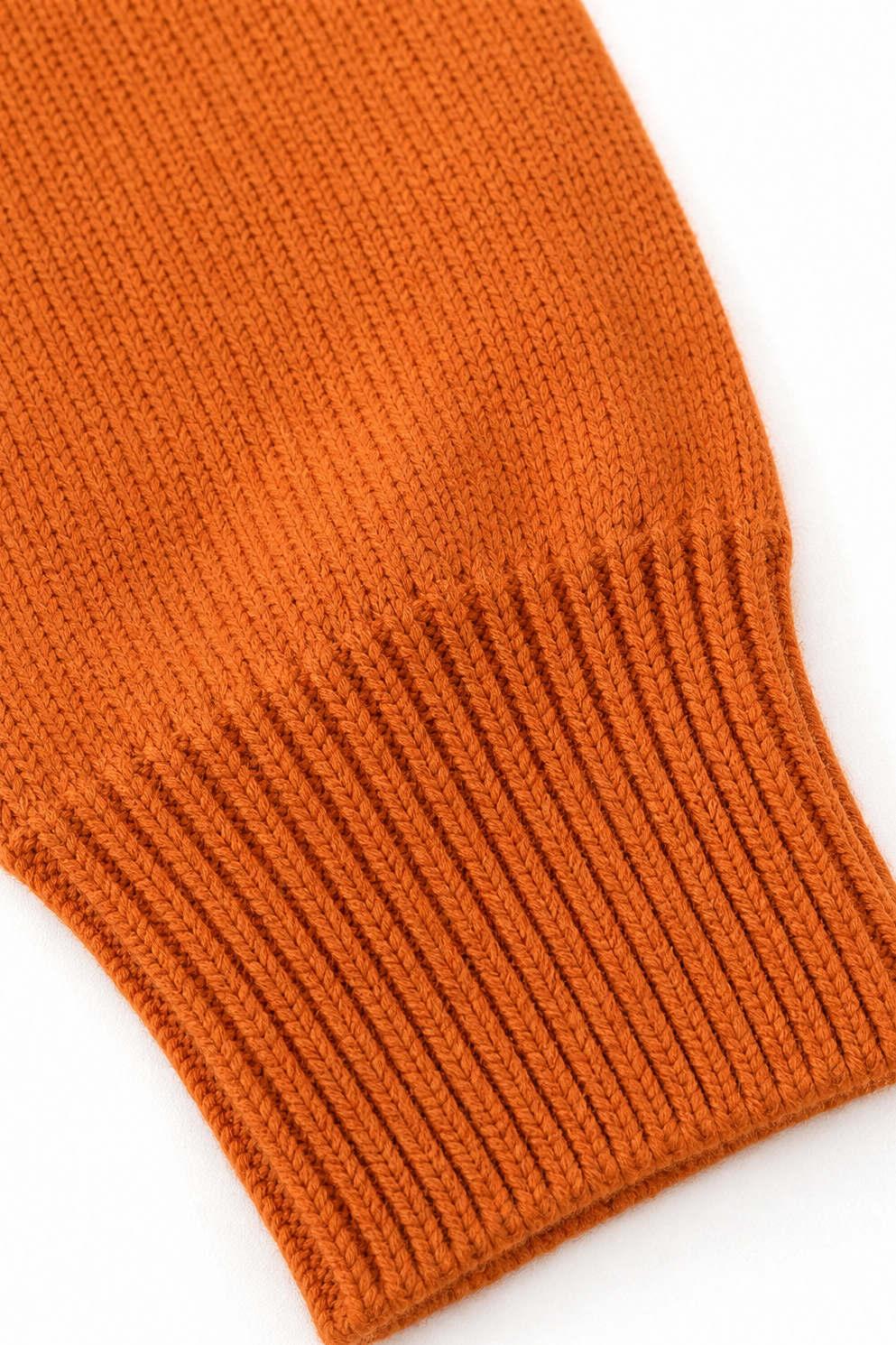 Close-up of the orange pullover sleeve ending in a wide ribbed cuff.