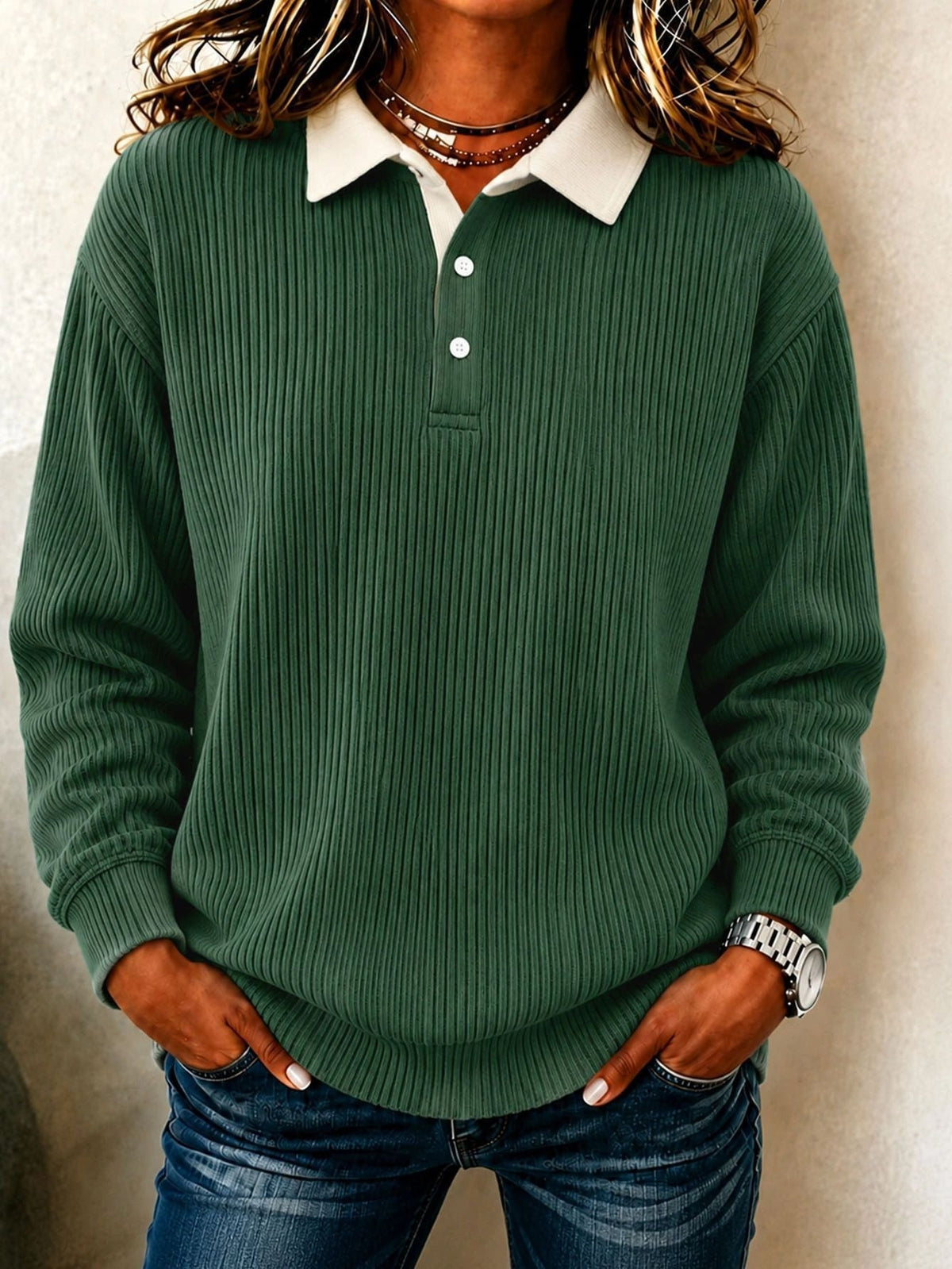 Deep green ribbed long-sleeve polo sweater with a cream collar, button placket, and fitted ribbed cuffs.