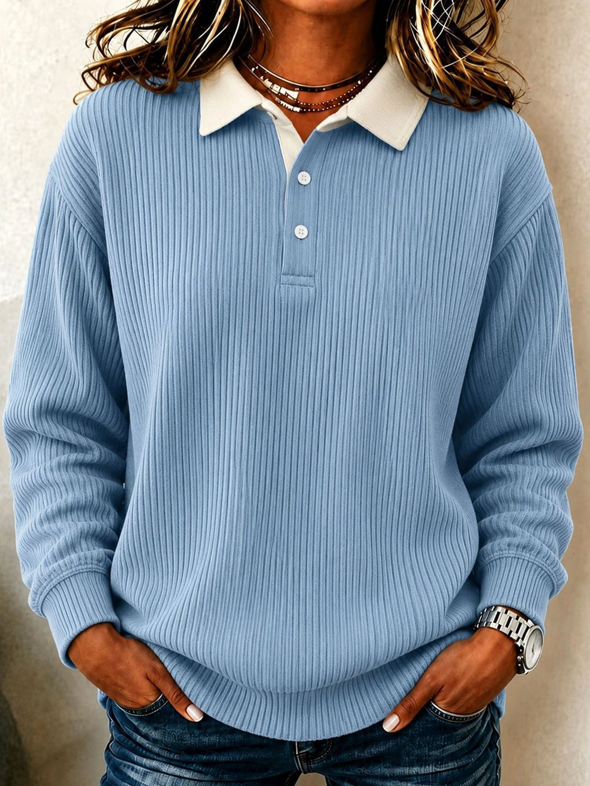 Pale blue ribbed polo sweater showing its contrasting cream collar, long sleeves, and rounded relaxed hem.