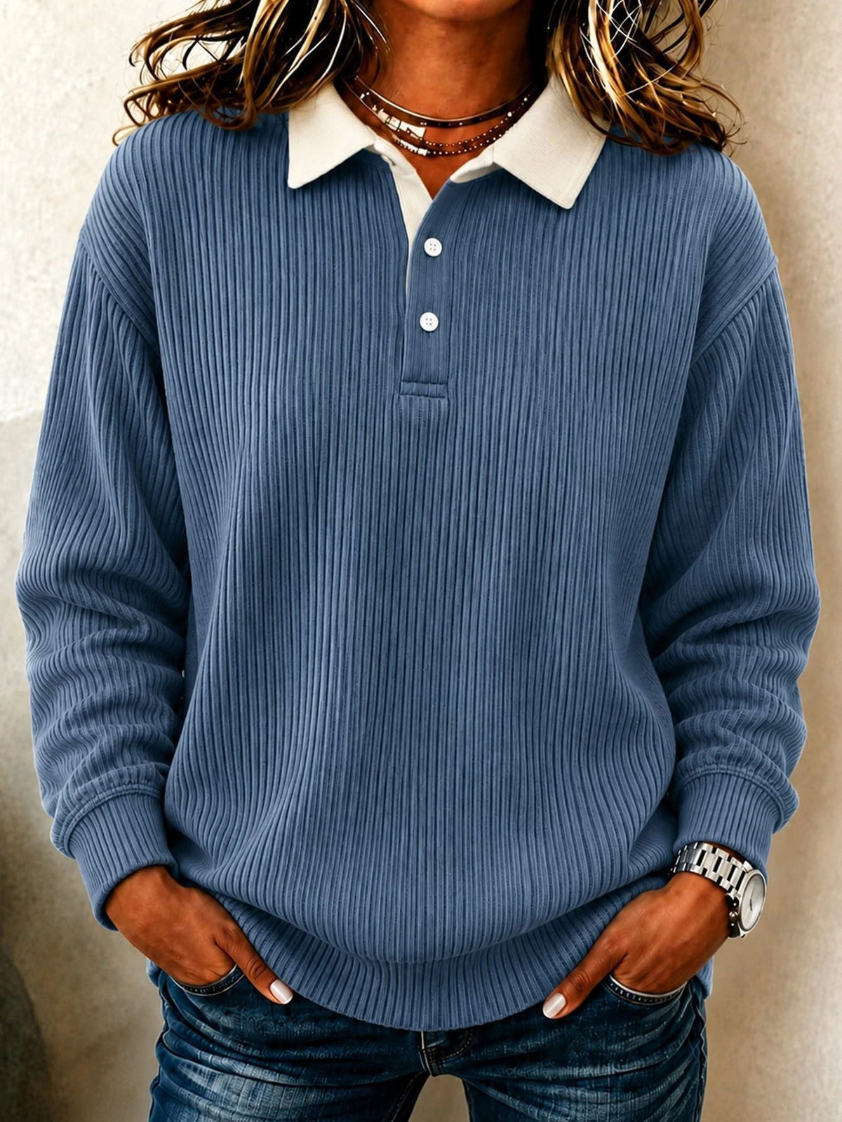 Slate blue ribbed long-sleeve polo sweater with a cream collar and visible two-button placket.