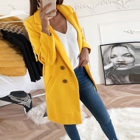Bright yellow single-breasted mid-thigh coat with notch lapels, two-button front, long sleeves, and angled hip pockets styled with jeans.