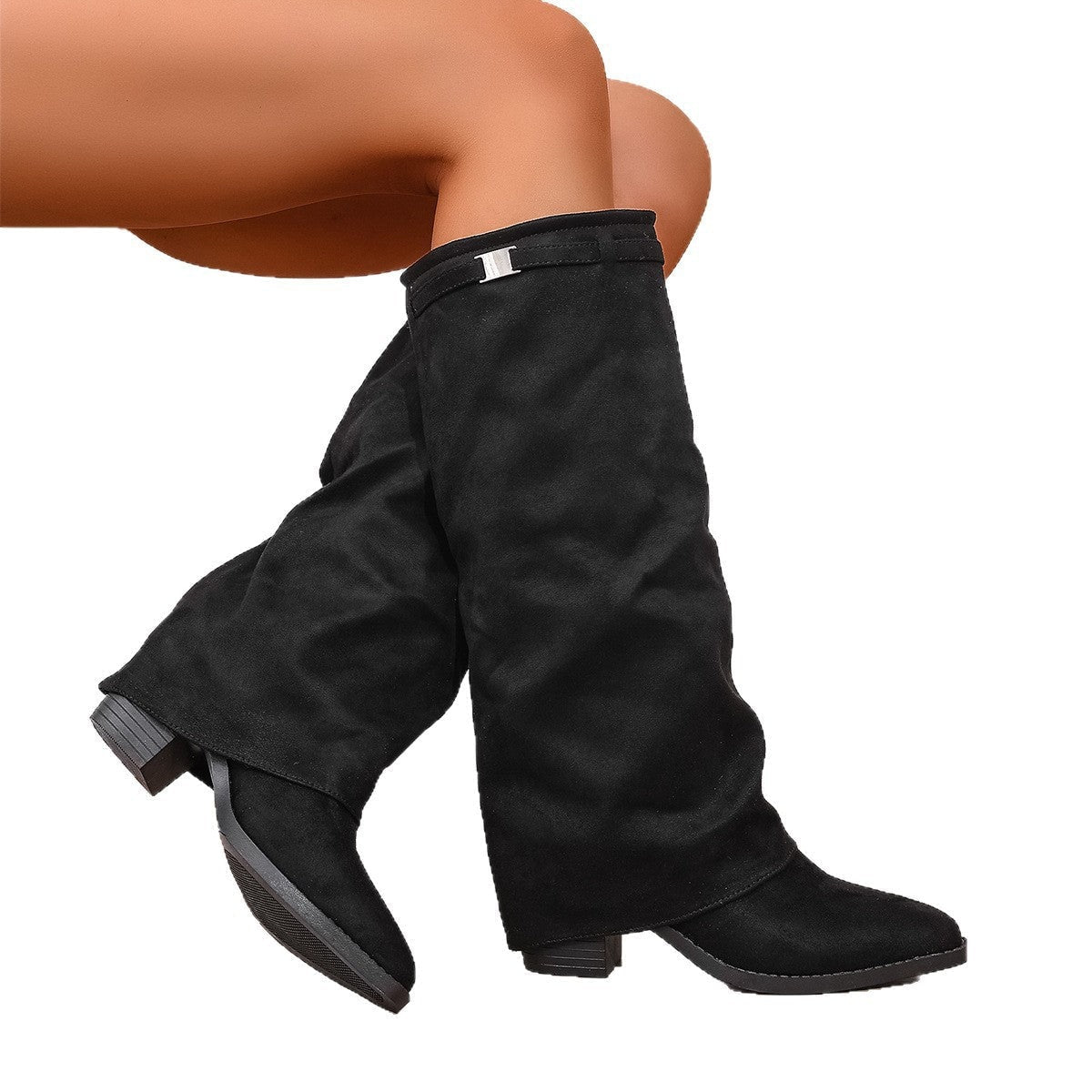 Black knee-high boots crossed against a white background, revealing the low block heels and textured outsoles.
