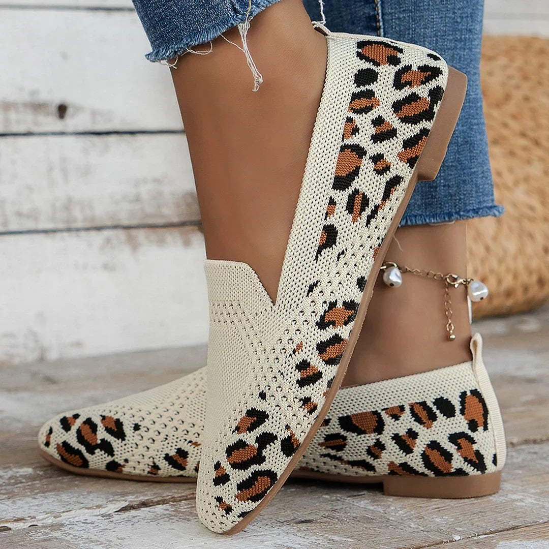 Cream slip-on flats with a leopard-print open-knit pattern shown in profile, highlighting the square toe and low heel.
