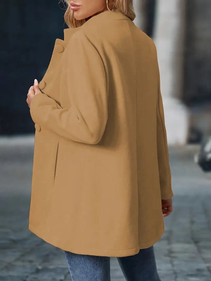 Rear three-quarter view of the tan coat, showing its long sleeves, smooth back, and rounded hem.