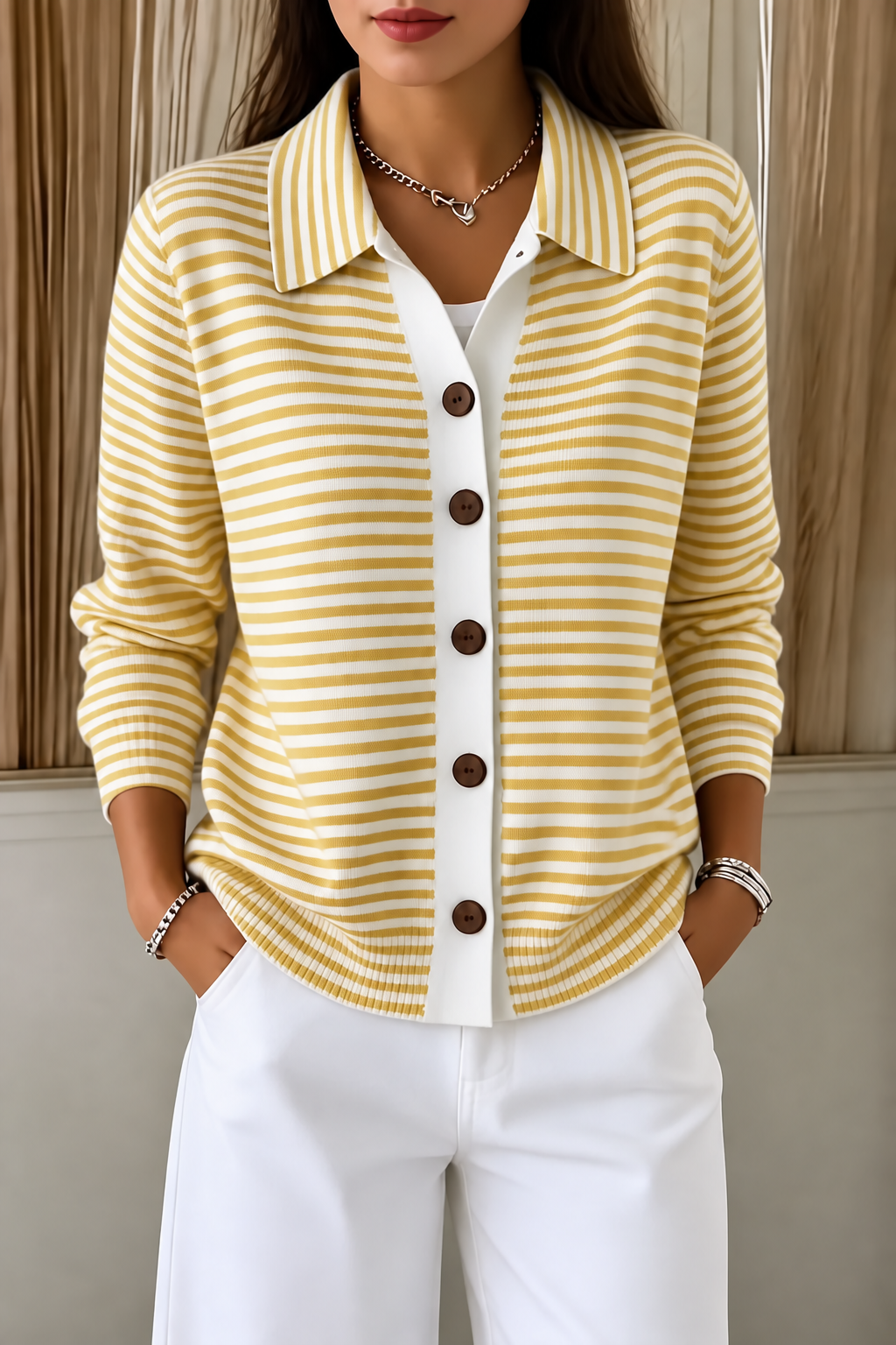 Front view of the yellow-and-white striped cardigan featuring a pointed collar and brown buttons.