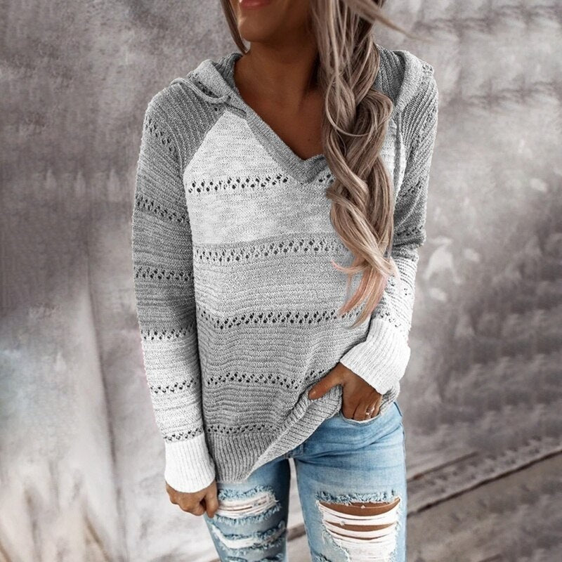 Front view of the gray and cream striped openwork sweater, showing the attached hood, V-neckline, and relaxed fit.