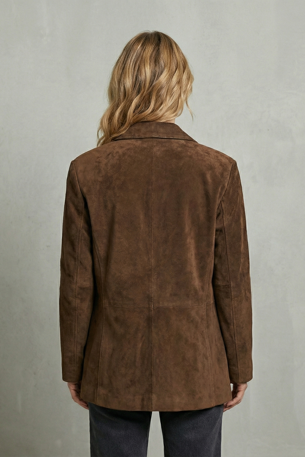 Back view of the brown longline blazer showing its structured shoulders, center back seam, shaped waist, and extended hem.