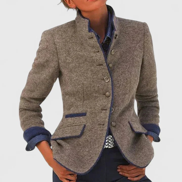 Taupe tailored cardigan jacket shown on a model, highlighting the blue contrast edging, cuff turn-backs, button front, and flap pockets.