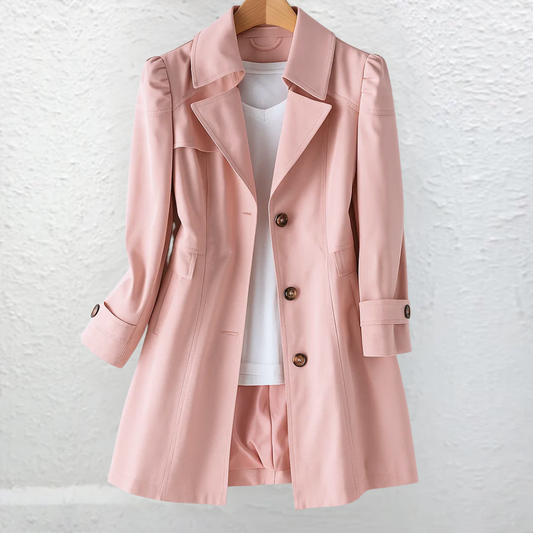 Front view of a pink tailored trench coat featuring a wide collar, double-breasted button detail, angled pockets, and buttoned cuff tabs.