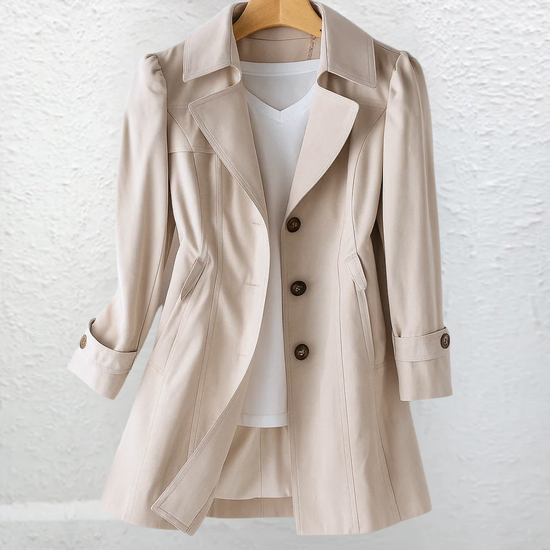 Front view of a light beige tailored trench coat with an open overlapping lapel, three visible buttons, angled pockets, long sleeves, and a gently flared hem.